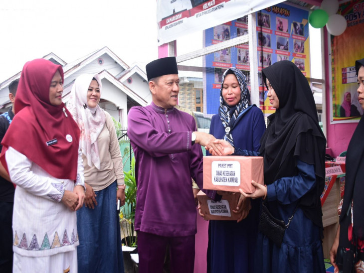 Bersama Pj Bupati Kampar,  Ketua Pembina Posyandu Kampar Ricana Djayanti Serahkan Bantuan Makanan Tambahan 
