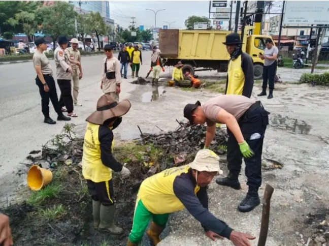 Antisipasi Banjir, Kapolsek Binawidya Pimpin Gotong Royong Bersihkan Parit di Jalan HR Subrantas